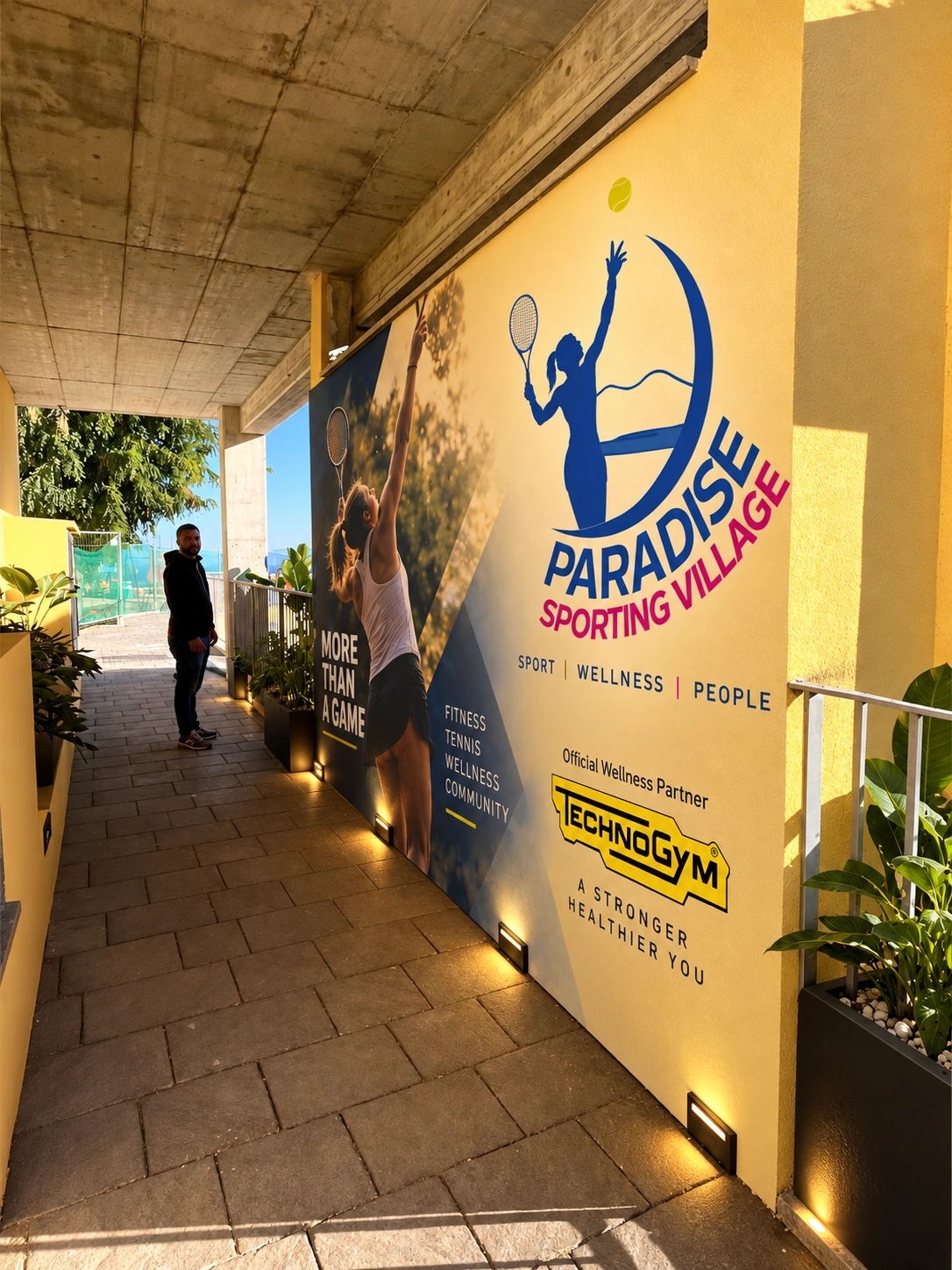 Ingresso del Paradise Sporting Village con la parete che presenta il marchio del circolo